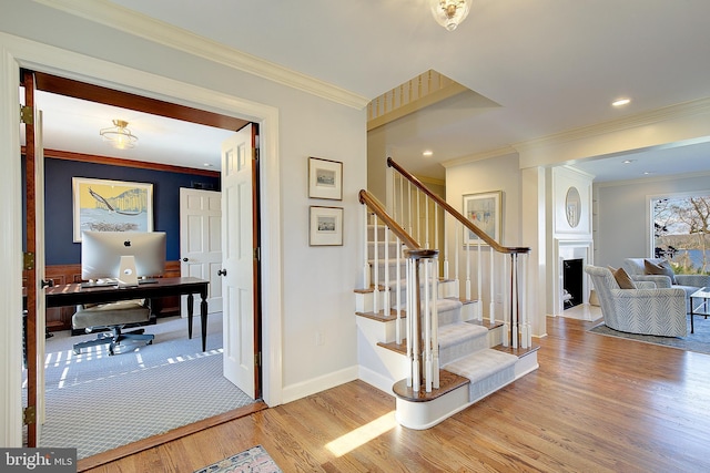 stairway with crown molding and hardwood / wood-style flooring