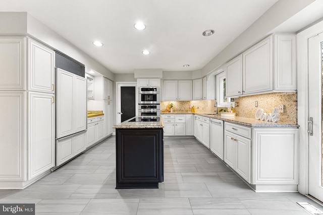 kitchen with dishwasher, light stone counters, white cabinets, a kitchen island, and stainless steel double oven