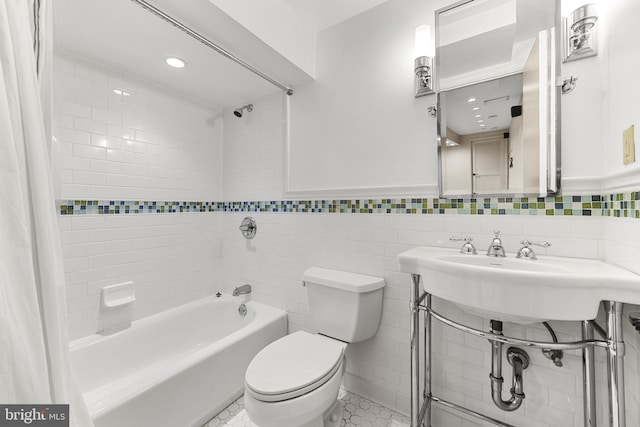 bathroom featuring tile walls, shower / bathtub combination with curtain, and toilet