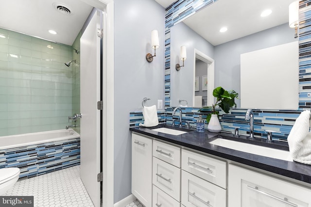 bathroom with tasteful backsplash, vanity, toilet, and tile patterned flooring