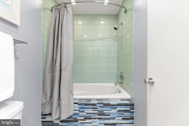 bathroom featuring shower / tub combo and toilet