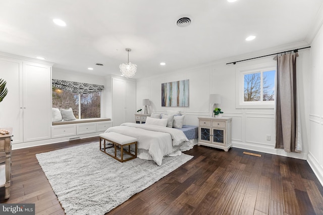 bedroom with ornamental molding, dark hardwood / wood-style floors, and an inviting chandelier