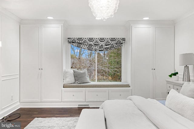 bedroom featuring dark wood-type flooring, crown molding, and an inviting chandelier