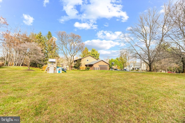 view of yard featuring a garage and a playground