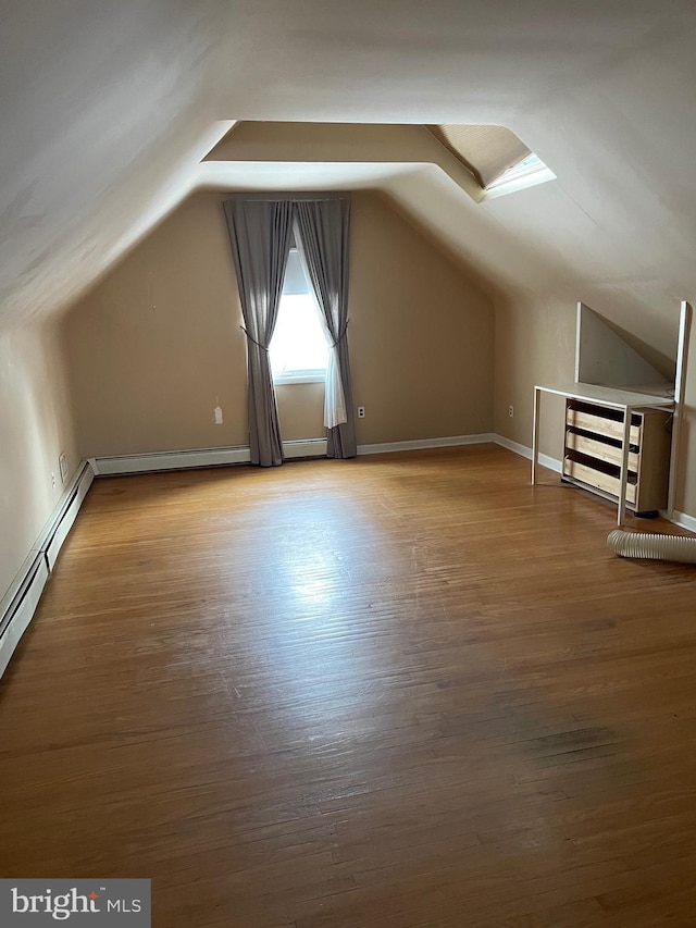 additional living space featuring vaulted ceiling and wood-type flooring