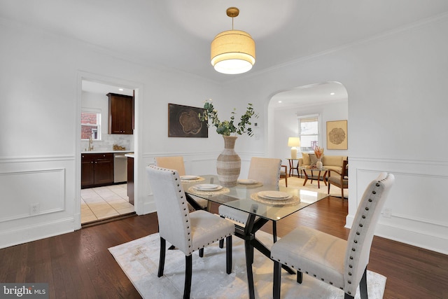 dining space with crown molding and light hardwood / wood-style flooring