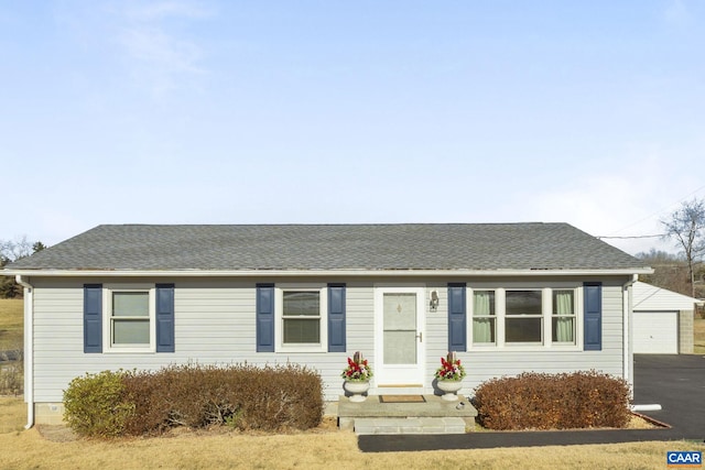 ranch-style home with an outbuilding, a garage, and a front lawn