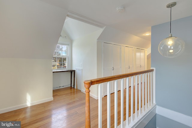 hall with hardwood / wood-style flooring and vaulted ceiling