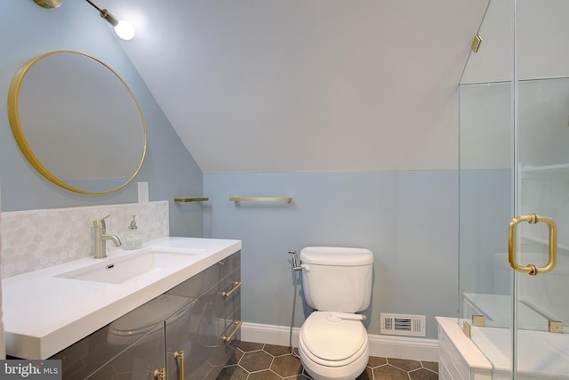 bathroom with an enclosed shower, vanity, vaulted ceiling, tile patterned floors, and toilet