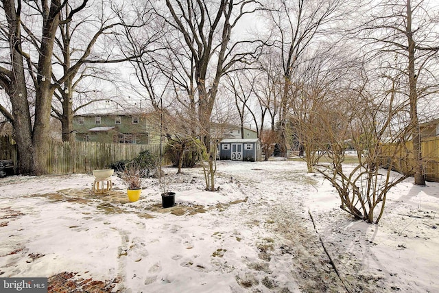 yard covered in snow with a storage shed