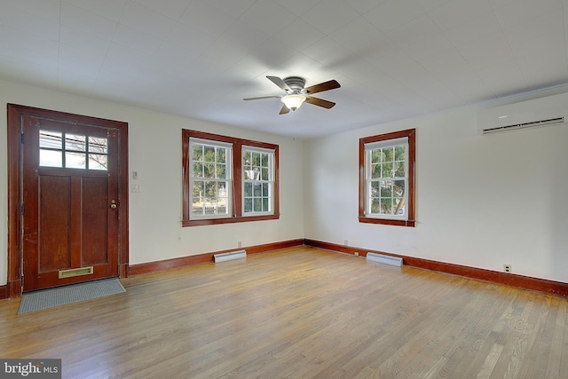 entrance foyer with a wall mounted air conditioner, light hardwood / wood-style floors, ceiling fan, and baseboard heating