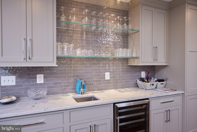 bar with light stone countertops, wine cooler, decorative backsplash, and sink