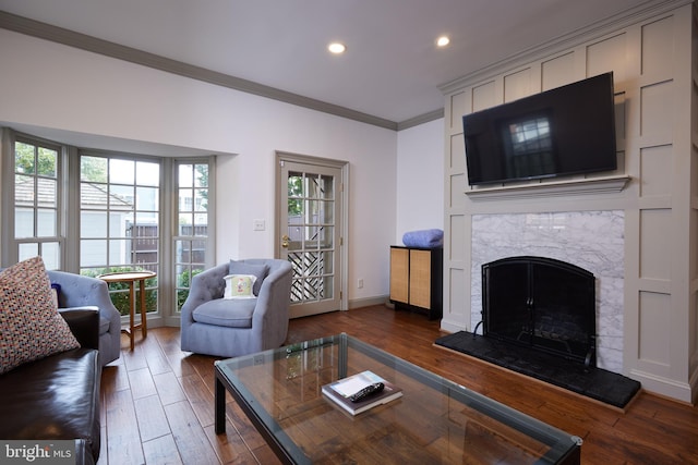 living room featuring wood-type flooring, ornamental molding, and a fireplace