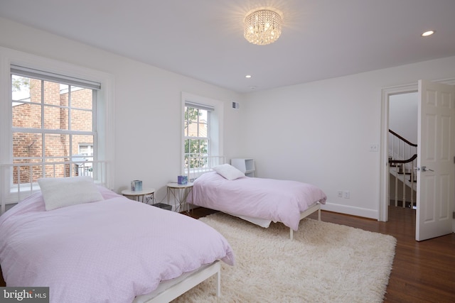 bedroom featuring dark wood-type flooring and a notable chandelier