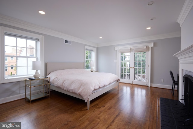 bedroom with crown molding, a fireplace, french doors, access to exterior, and dark hardwood / wood-style floors