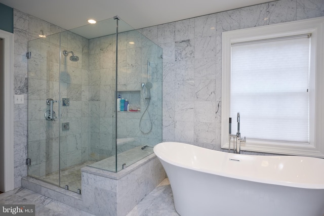 bathroom featuring separate shower and tub and tile walls