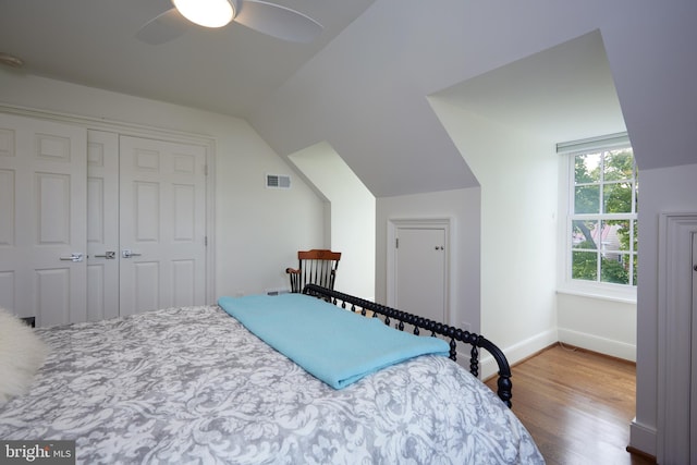 bedroom featuring lofted ceiling, hardwood / wood-style flooring, a closet, and ceiling fan