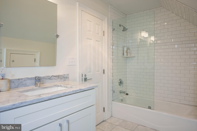 bathroom with tiled shower / bath combo, vanity, and tile patterned flooring