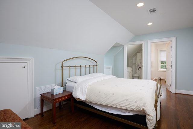 bedroom featuring vaulted ceiling, connected bathroom, and dark wood-type flooring