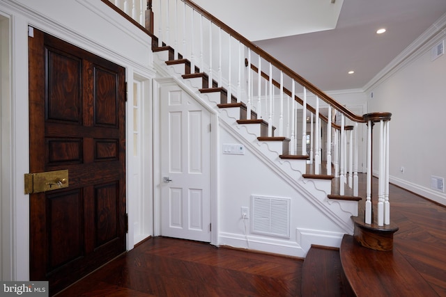 entryway with crown molding and dark parquet floors