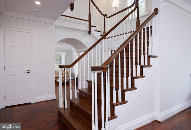 staircase featuring ornamental molding and parquet flooring