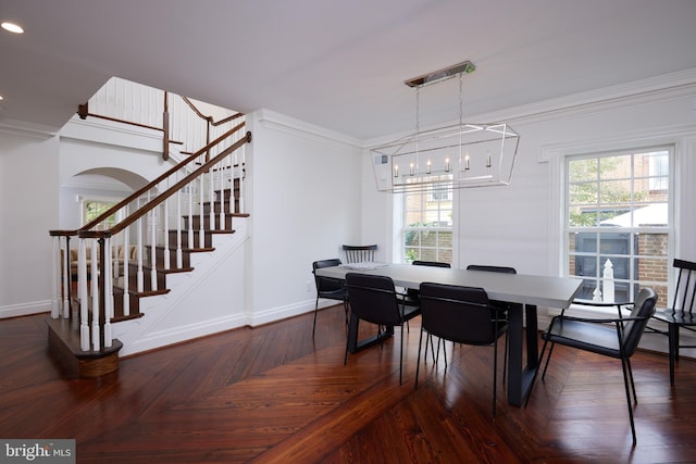 dining room featuring plenty of natural light, crown molding, and dark parquet floors