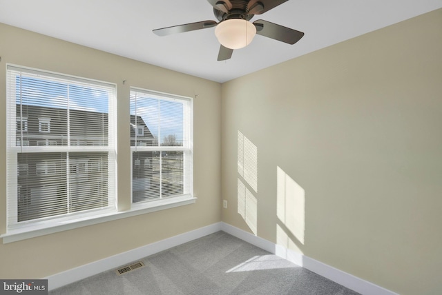 spare room featuring light colored carpet and ceiling fan