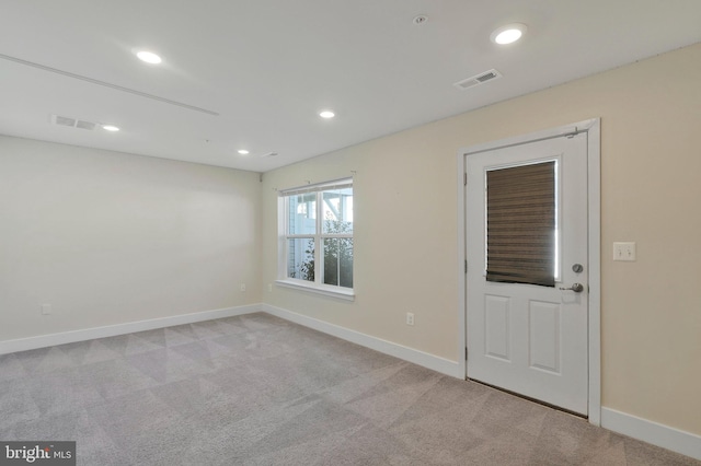 spare room featuring light colored carpet