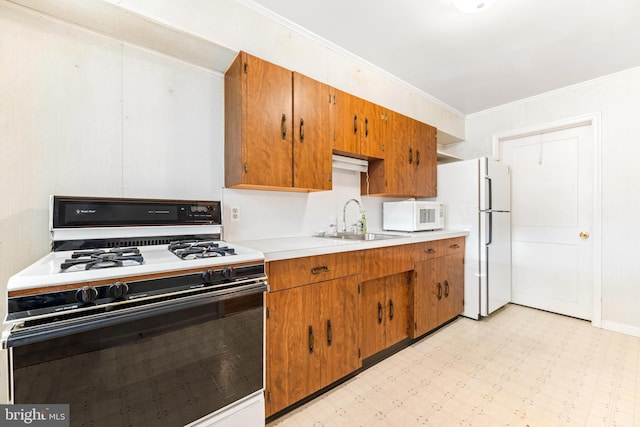 kitchen with crown molding, sink, and white appliances