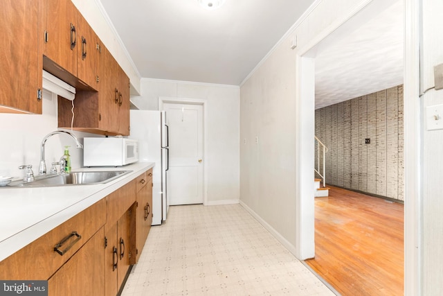 kitchen with ornamental molding, sink, and white appliances