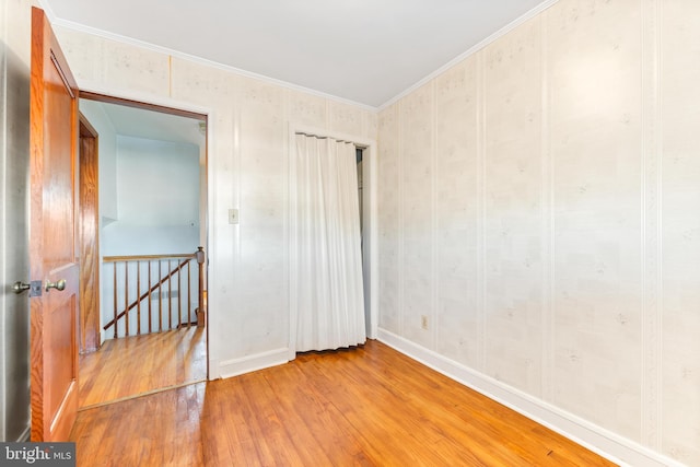 unfurnished bedroom featuring crown molding and light wood-type flooring