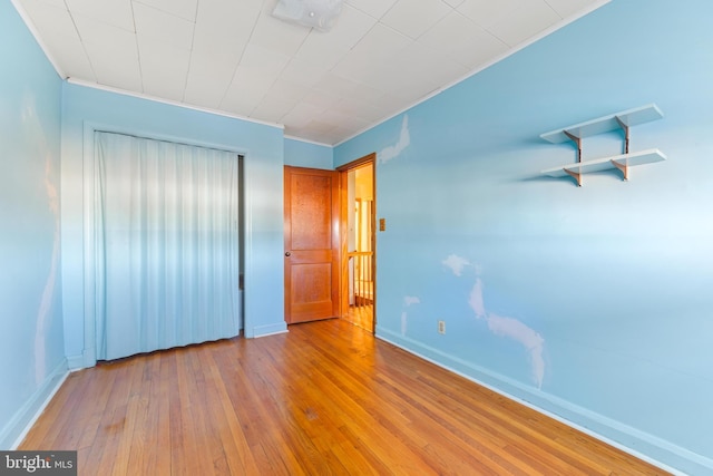 unfurnished bedroom featuring crown molding and light wood-type flooring