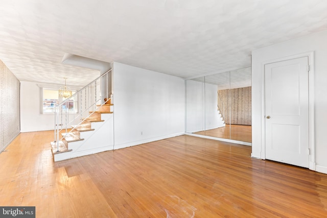 basement featuring an inviting chandelier and wood-type flooring