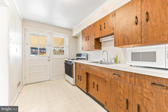 kitchen featuring ornamental molding, sink, and gas range oven