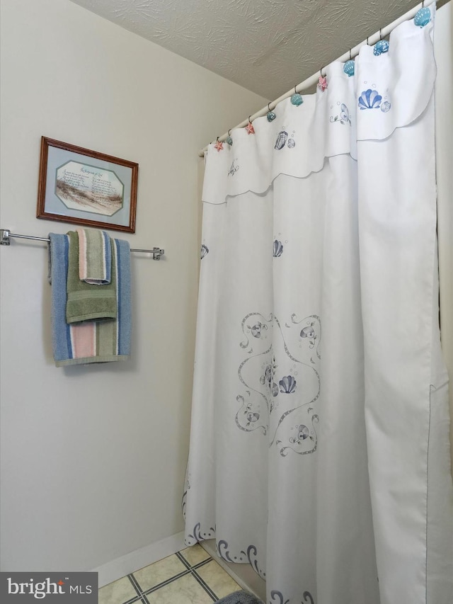 bathroom with tile patterned floors and a textured ceiling