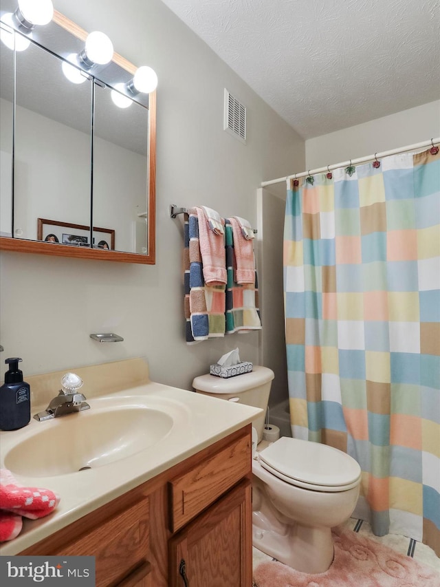 bathroom featuring vanity, a textured ceiling, and toilet