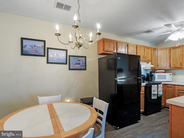 kitchen featuring ceiling fan with notable chandelier, decorative light fixtures, dark wood-type flooring, and black appliances