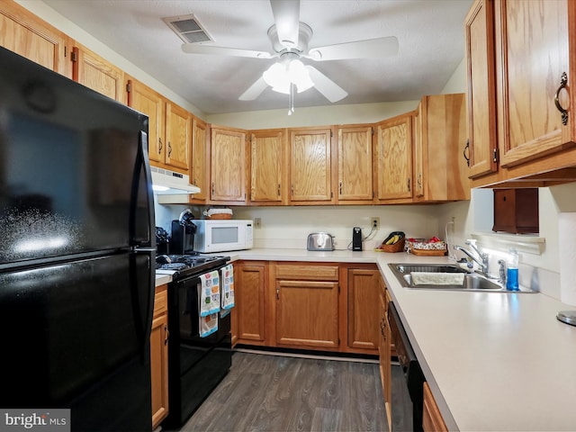 kitchen with sink, dark wood-type flooring, black appliances, and ceiling fan