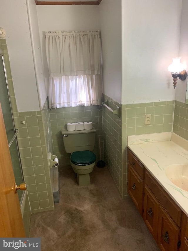 bathroom with toilet, vanity, and tile walls