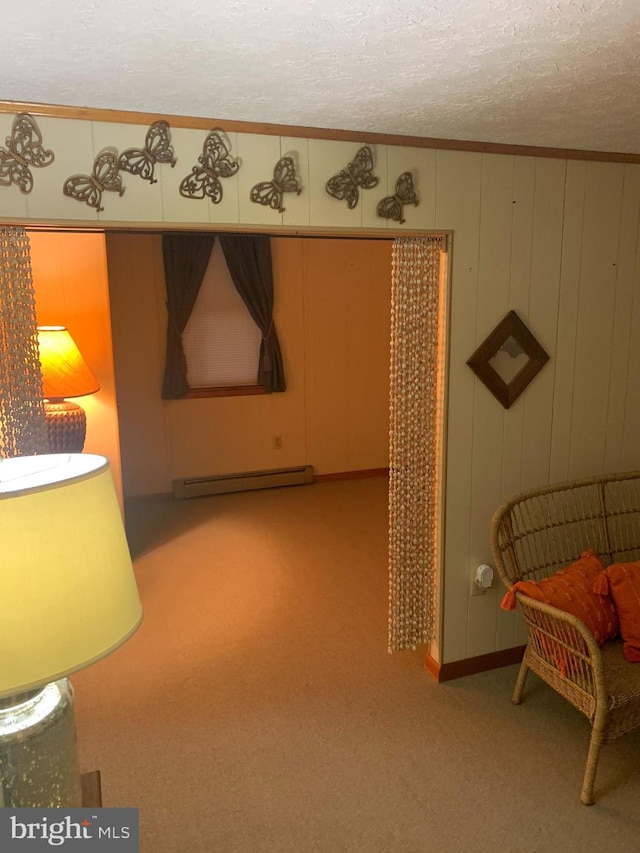 sitting room featuring ornamental molding, light colored carpet, a baseboard heating unit, and a textured ceiling