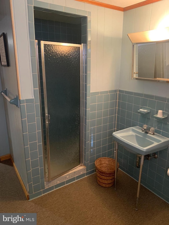 bathroom featuring sink, ornamental molding, and an enclosed shower