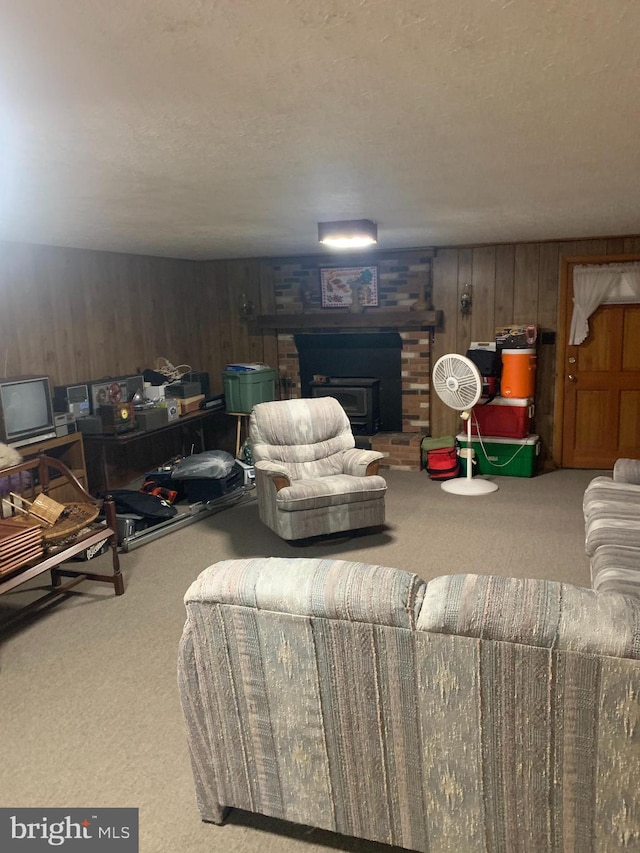 living room with wood walls, a textured ceiling, and carpet flooring