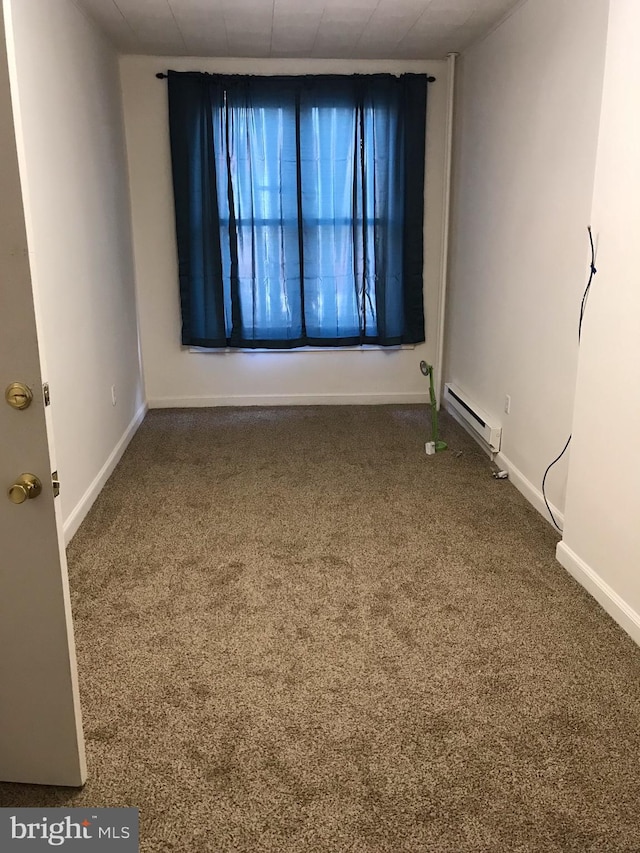 empty room with carpet flooring and a baseboard radiator