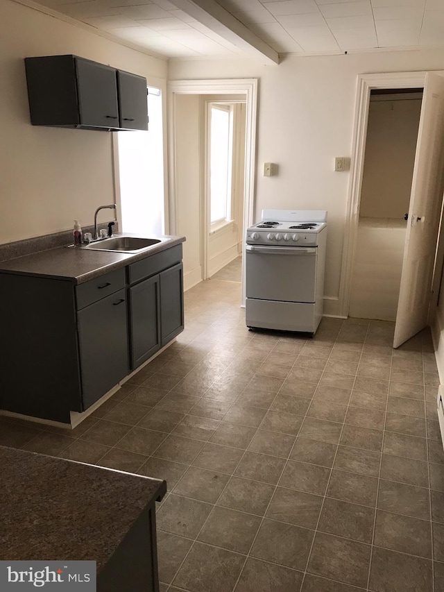 kitchen with sink, beam ceiling, and electric stove