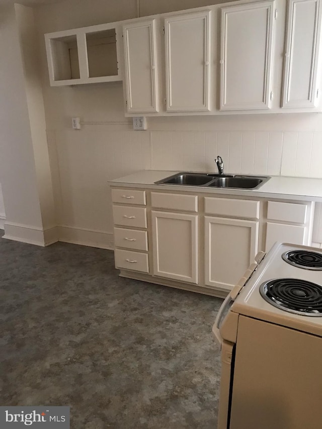 kitchen featuring decorative backsplash, sink, white cabinets, and white electric range