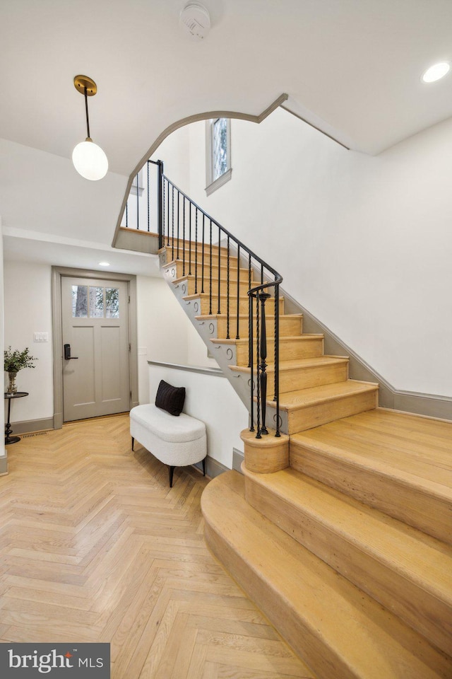 entryway featuring parquet flooring and a towering ceiling