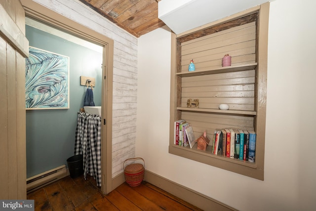 interior details with hardwood / wood-style flooring, a baseboard heating unit, and wooden walls