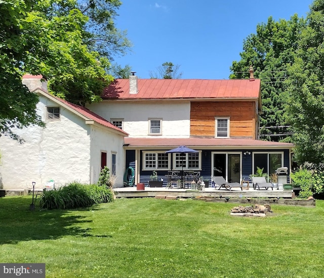 back of house featuring a wooden deck and a lawn