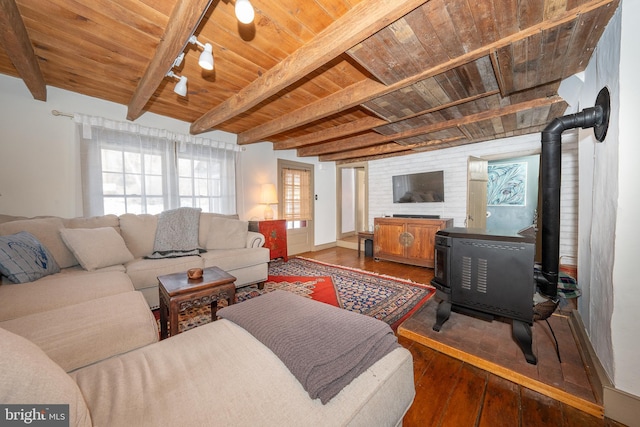 living room featuring beamed ceiling, a wood stove, wood ceiling, and dark hardwood / wood-style floors