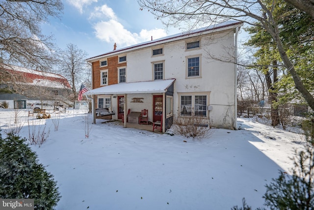 view of snow covered back of property